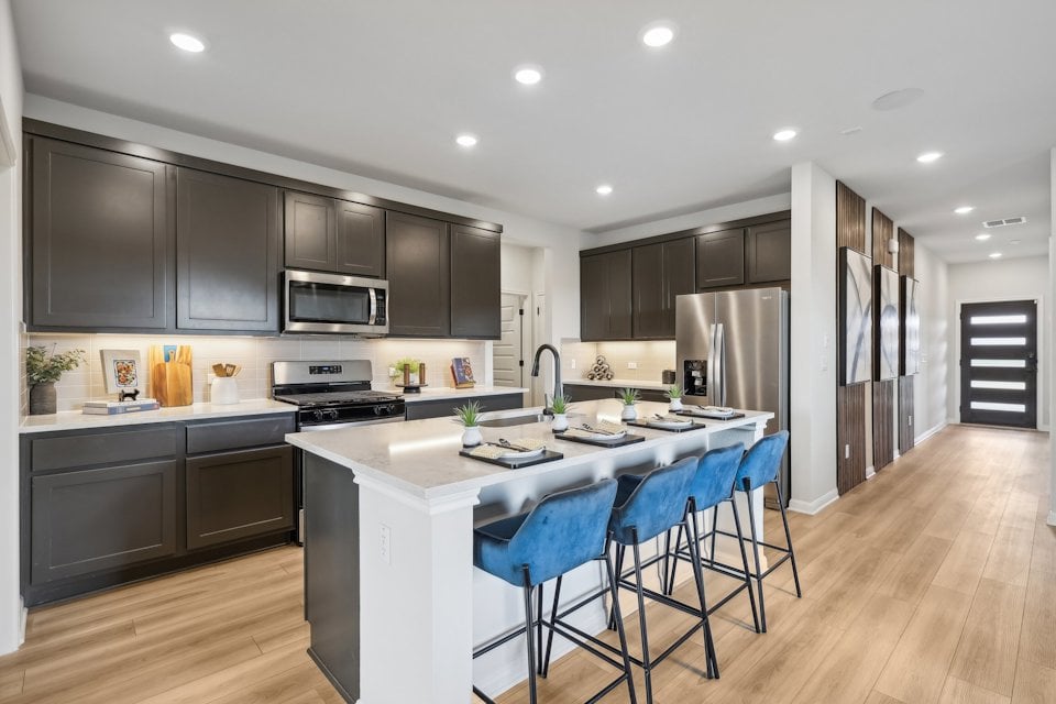 A kitchen with black cabinets.
